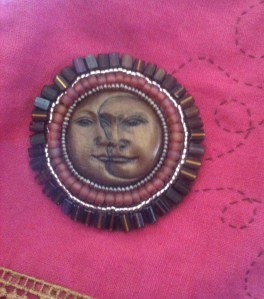 Face Cabochon secured to linen jacket.
