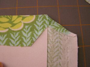 Fold raw edge down at corner.