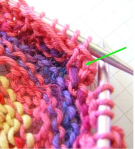Hole closing stitches knit together.  Green arrow identifies stitch to pick up for hidden increase.