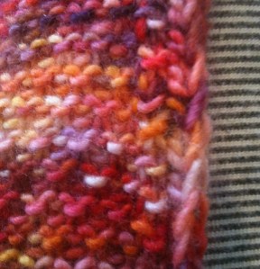 Wrong Side.  Carry yarn is hidden in the first edge stitch.