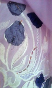 Embellishment on vertical lace piece.